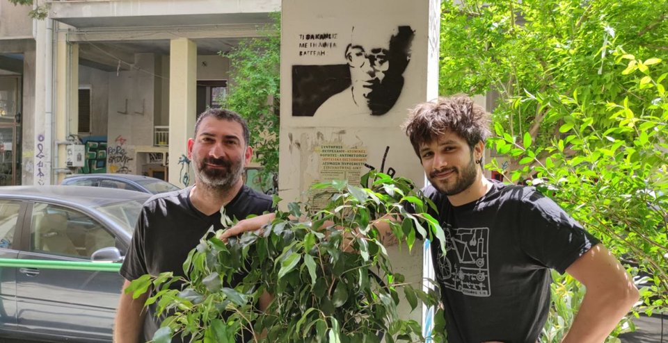  Οικονομίδης και Νιάρρος μαζί για το Σπιρτόκουτο που γίνεται μιούζικαλ. Χαμογελούν κάτω από ένα μίνι γκράφιτι της πόλης με την εμβληματική φράση της ταινίας «τι θα κάνεις με την Λίντα Βαγγέλη;» / Φωτογραφία Κατερίνα Ι. Ανέστη 