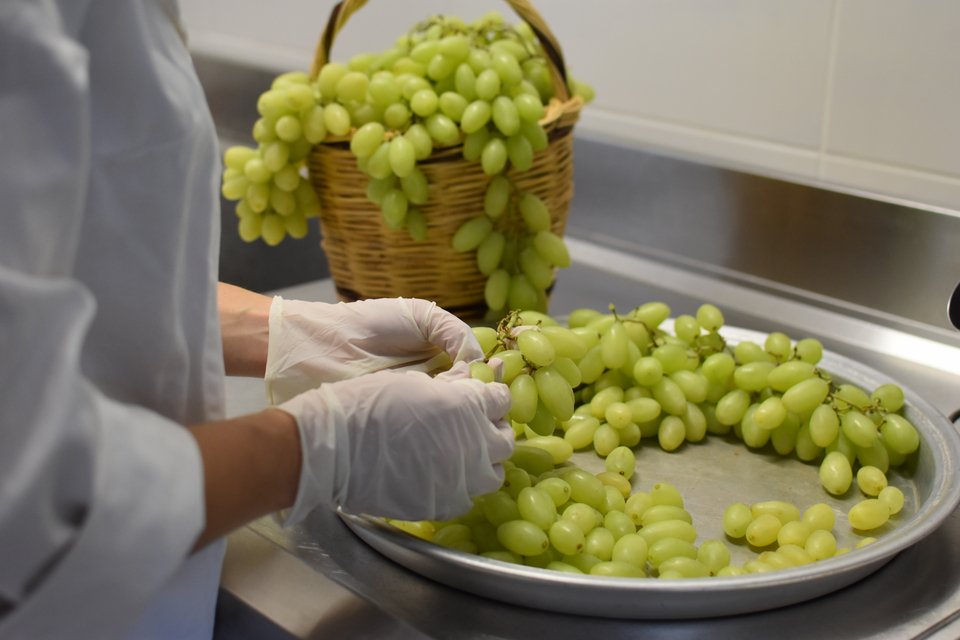 Στο εργαστήριο η Χάρις διαλέγει μία-μία τις ρώγες από τα τσαμπιά του σταφυλιού για να φτιάξει γλυκό του κουταλιού