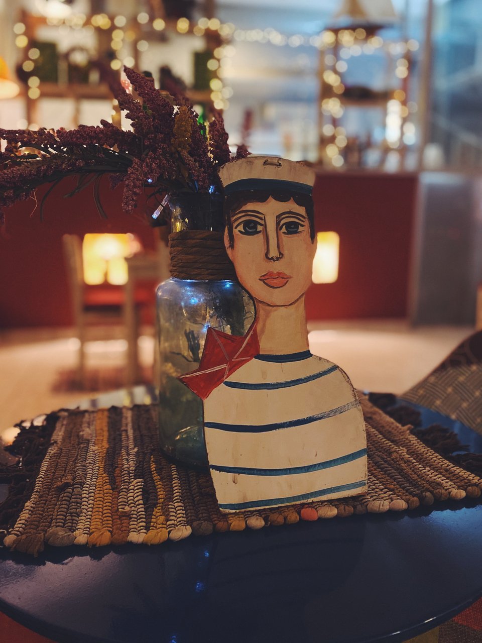 Ξύλινα διακοσμητικά, σουπλά από κουρελού και αποξηραμένα βότανα και μυρωδικά από την Κρήτη, στολίζουν τα τραπέζια. 