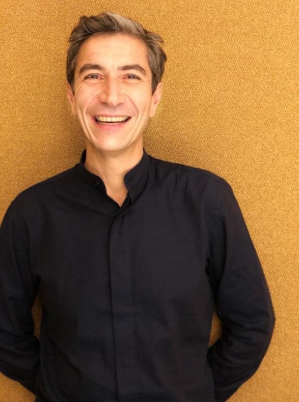 Ο Γιάννης Σεργάκης ζει μεταξύ Παρισιού και Αθήνας -στη σκιά της Ακρόπολης κυριολεκτικά-, περνάει τα καλοκαίρια του στα νησιά και εμπνέεται από απλές βραδιές με φίλους μέχρι το μεγαλείο της αρχαιότητας