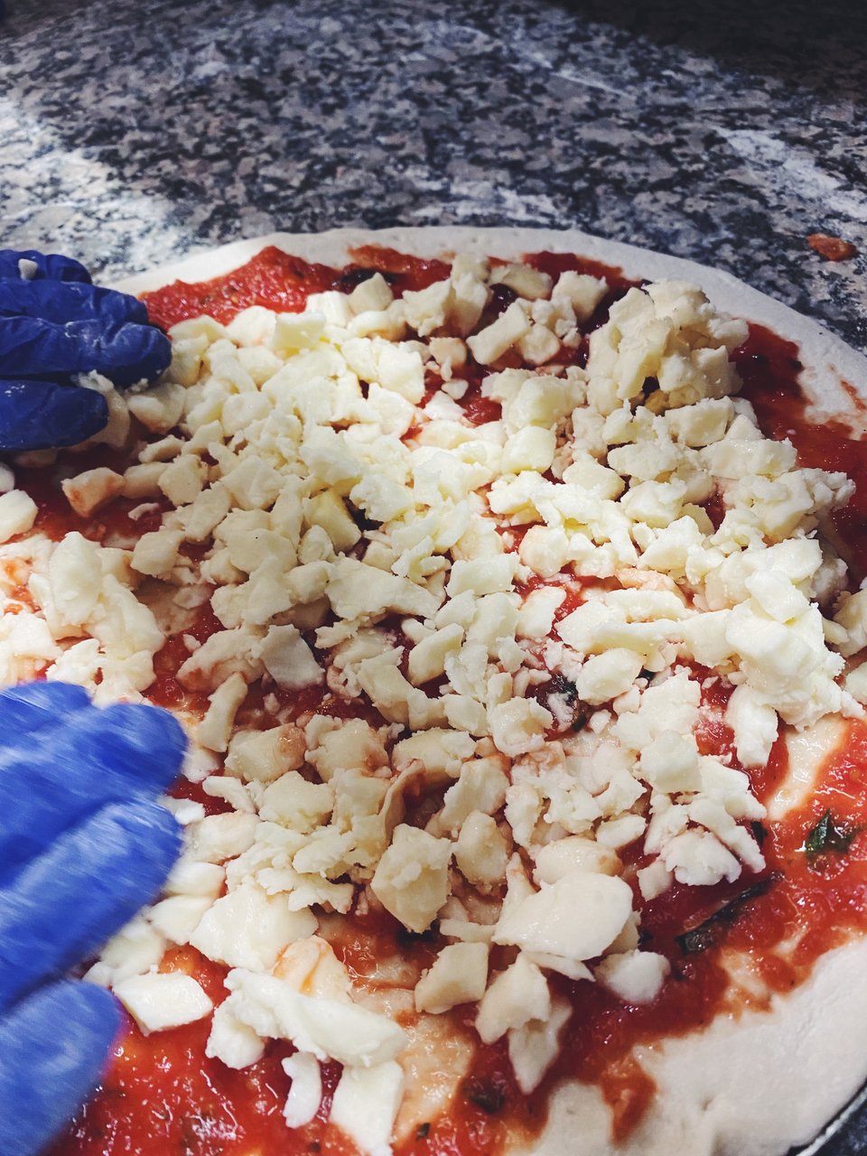 Πάνω από τη σάλτσα ντομάτας μπαίνει η ιταλική μοτσαρέλα. 