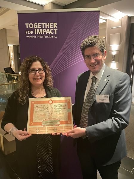 Ο Λεόν Σαλτιέλ παραδίδει τη μετοχή στη διευθύντρια του Εβραϊκού Μουσείου Ελλάδος Ζανέτ Μπαττίνου