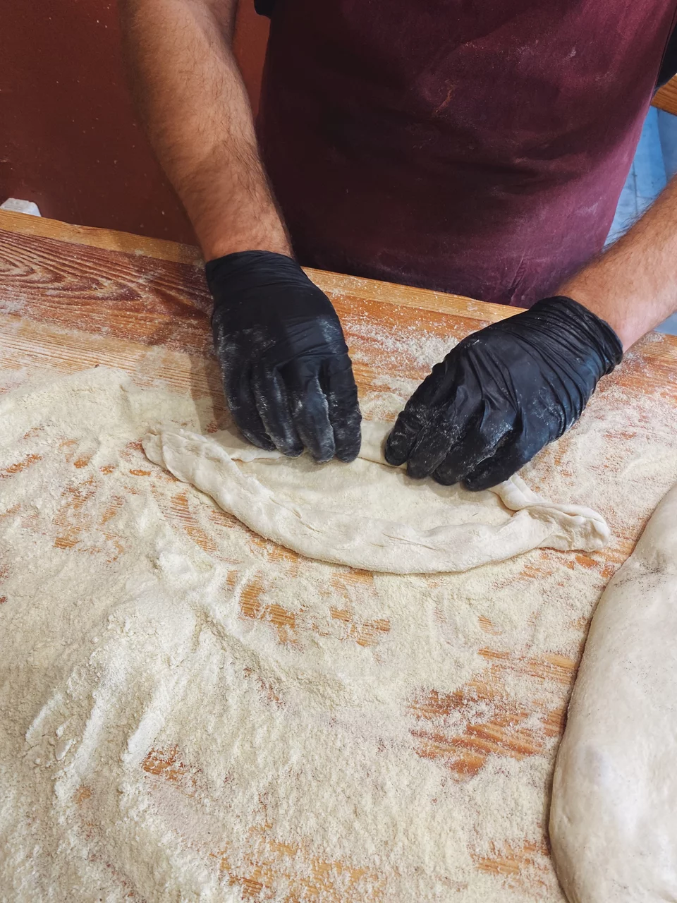 Το ζυμάρι με το χέρι παίρνει το σχήμα του πεϊνιρλί.