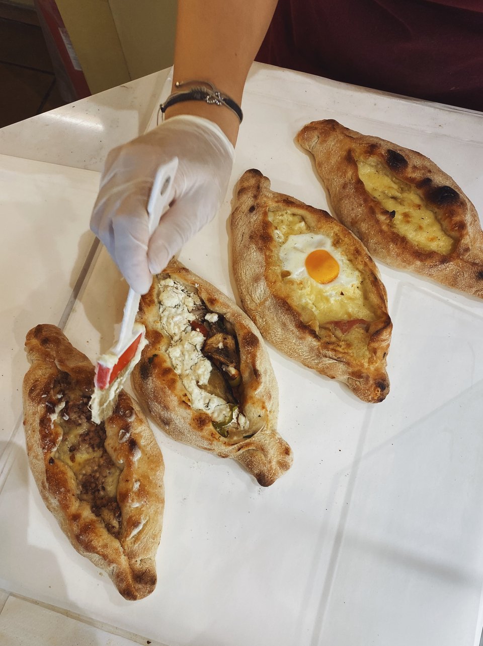 Πριν τα δώσουν στον πελάτη περνάνε με πινέλο τα πεϊνιρλί με μια ελαφριά στρώση από αιγοπρόβειο και αγελαδινό βούτυρο. Αυτό δίνει μια πολύ ωραία ζουμερή αίσθηση στη ζεστή ζύμη, καθώς το βούτυρο λιώνει πάνω της. 