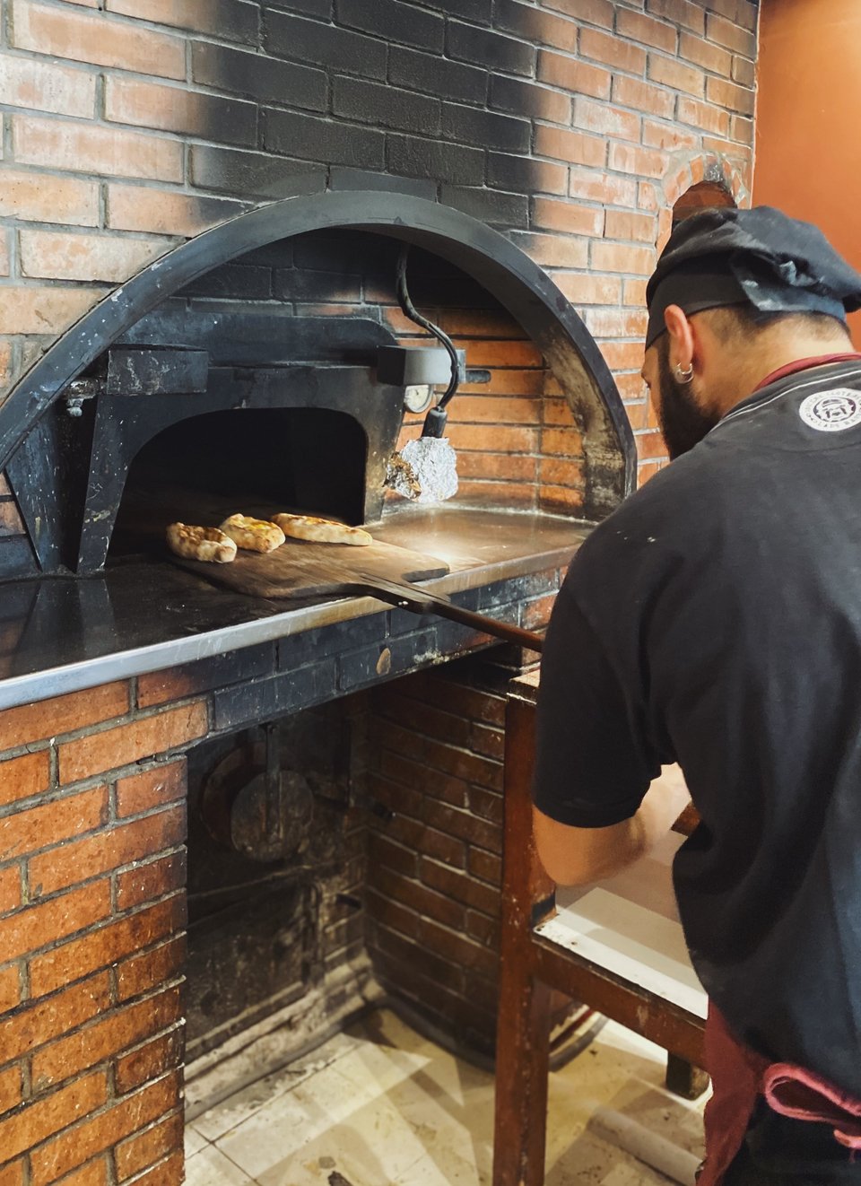 Μετά από λίγα λεπτά στον ξυλόφουρνο τα πεϊνιρλί βγαίνουν με το μακρύ ξύλινο φτυάρι. 