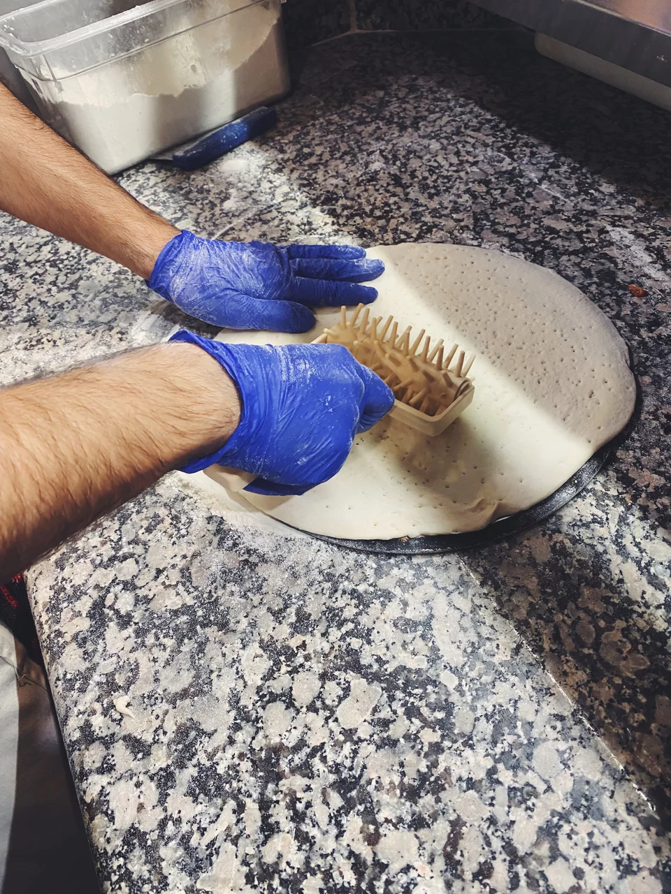 Με το ειδικό ρολό τρυπιέται η ζύμη για να φύγει ο αέρας.