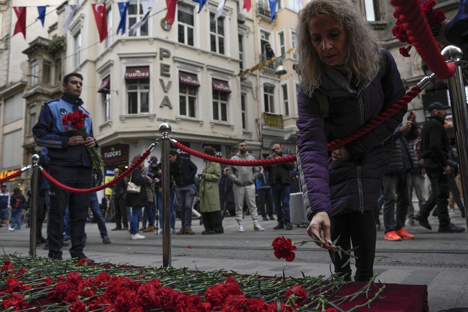 Περαστικοί αφήνουν λουλούδια στο σημείο της έκρηξης. Φωτογραφία από ASSOCIATED PRESS