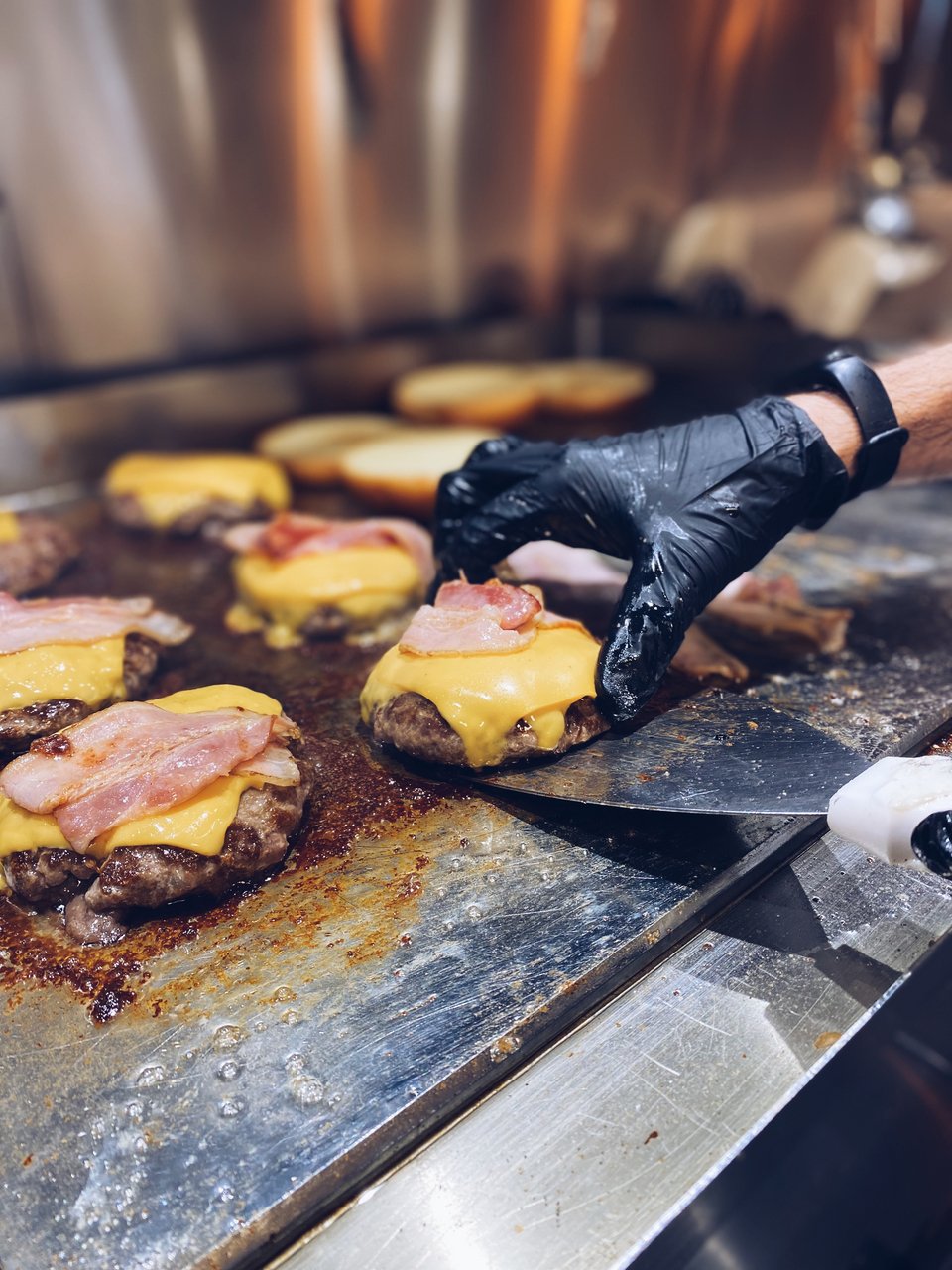 Ζουμερά μπιφτέκια ετοιμάζονται για τα ασταμάτητα delivery. To burger είναι το πιο δημοφιλές πιάτο του Gaby το βράδυ. 