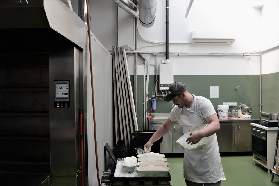 Τα ψωμιά έχουν μπει στις φόρμες και αλευρώνονται πριν μπουν στον φούρνο. 