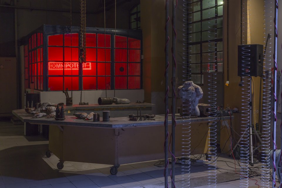 Στο εφαρμοστήριο της ΔΕΗ. Στο βάθος το έργο των Hypercomf, μπροστά της Αννας Μαυρομιχάλη και σε πρώτο πλάνο με τα ελατήρια και τα μαγάφωνα το Οther than the Ear» του Jeph Vanger.