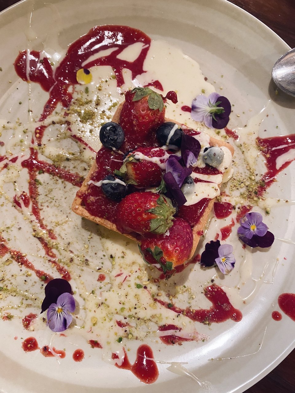 Η τάρτα λεμονιού με φράουλες και λουλούδια είναι ένα γλυκό σαν πίνακας ζωγραφικής. 