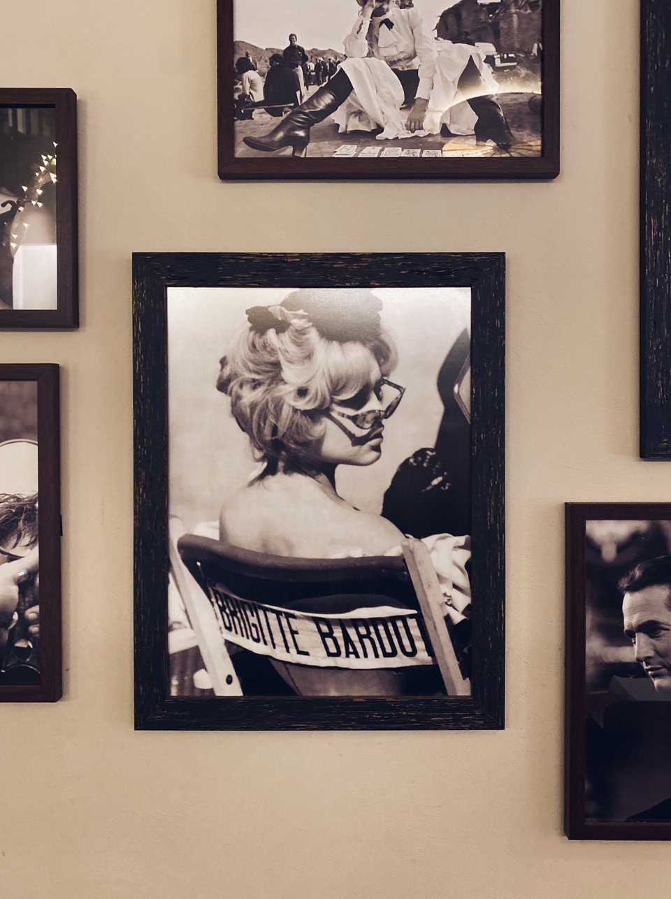 Κάδρα με φωτογραφίες από προσωπικότητες της Ιταλίας κοσμούν τους τοίχους, όπως αυτό το ενσταντανέ της Μπριζίτ Μπαρντό