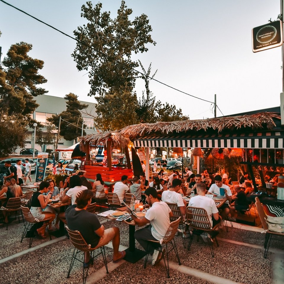 Τα τραπέζια του Wynwood απλώνονται γύρω από το μαγαζί στο τεράστιο πεζοδρόμιο της οδού Φοίβης