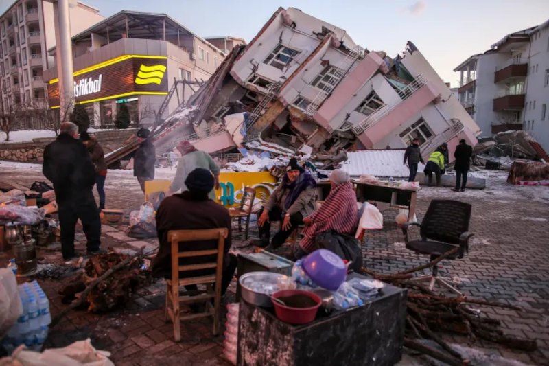 Σεισμόπληκτοι δίπλα στα ερείπια κτιρίων που κατέρρευσαν στο Γκόμπασι του Αντίγιαμαν της νότιας Τουρκίας