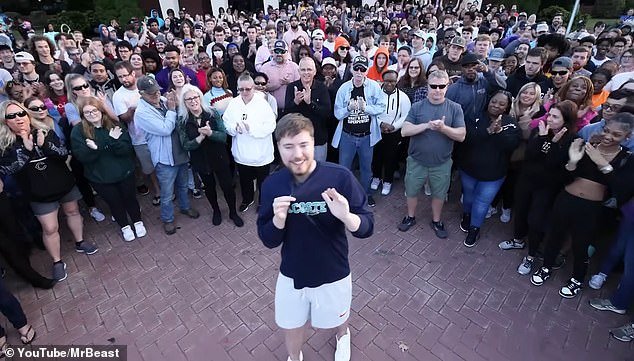 Ο MrBeast στέκεται μαζί με ένα πλήθος ανθρώπων, των οποίων βοήθησε να θεραπευτεί η όρασή τους