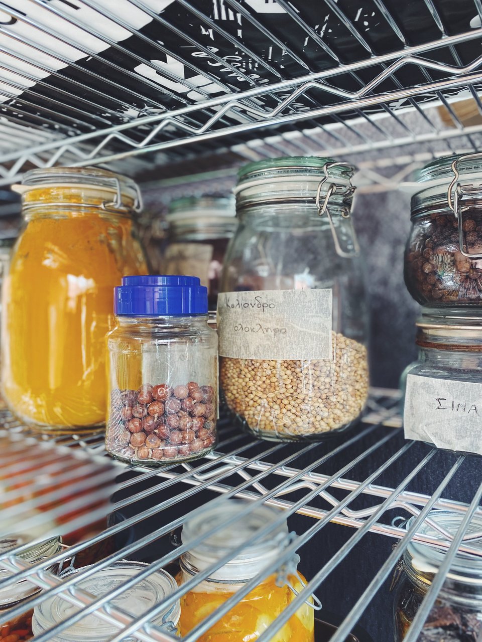 Στα ράφια του εργαστηρίου υπάρχουν δοχεία με βότανα, καρπούς, μυρωδικά που χρησιμοποιούνται στην παραγωγή των τουρσί / Φωτογραφία: Μάνος Λειβαδάρος/iefimerida