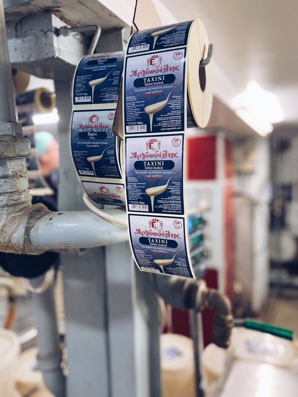 Τα δοχεία οδηγούνται σε έναν πάγκο για να μπουν τα αυτοκόλλητα με το brand  / Φωτογραφία: Μάνος Λειβαδάρος/iefimerida.gr