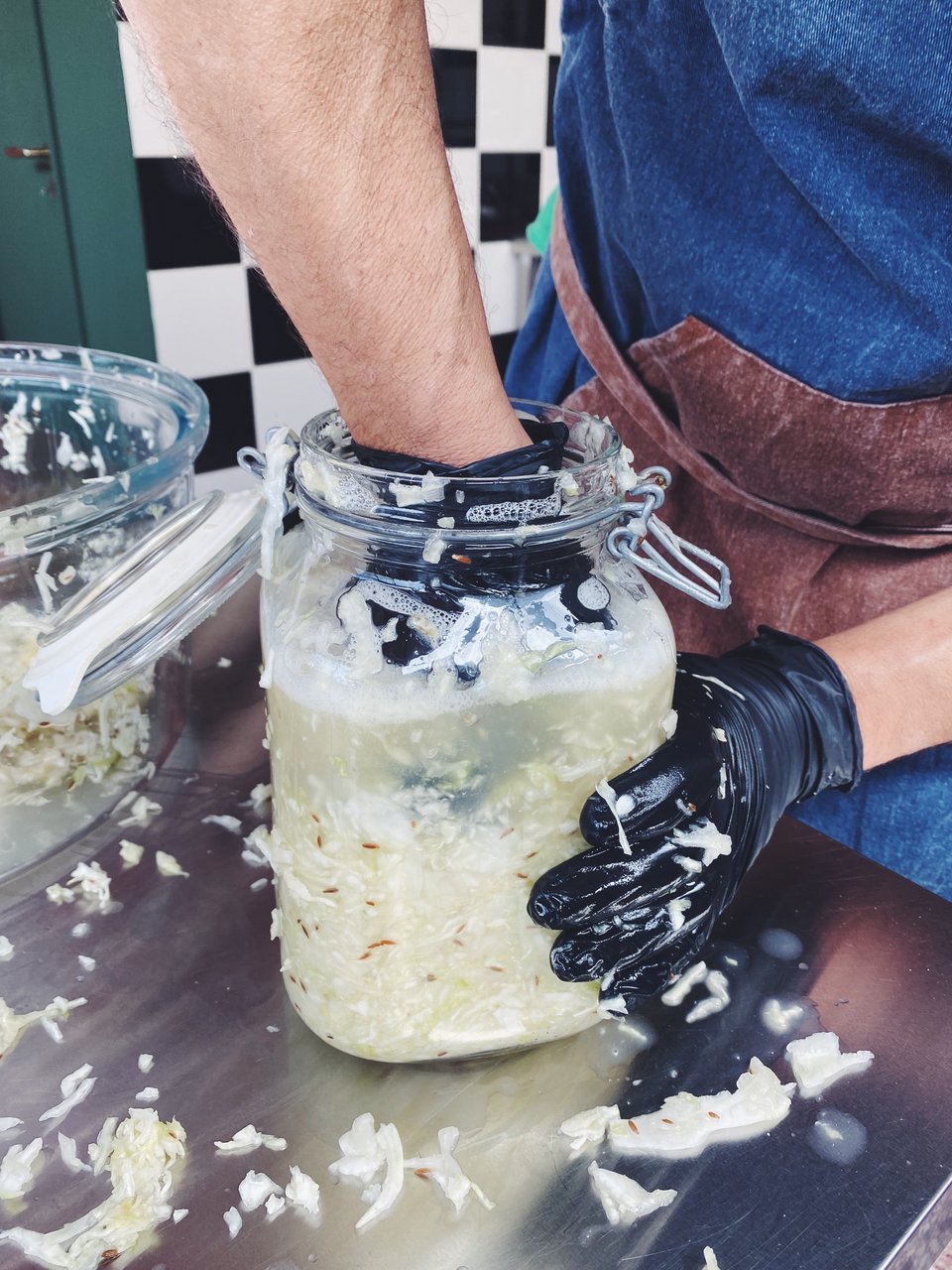 Ο Άγγελος πιέζει δυνατά το λάχανο μέσα στο δοχείο ώστε να βγάλει τους χυμούς του  / Φωτογραφία: Μάνος Λειβαδάρος/iefimerida