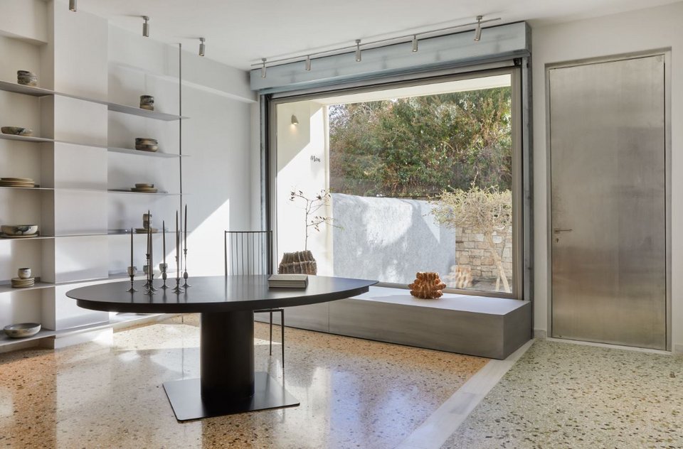 Ο πρώτος χώρος που συναντάς μπαίνοντας στο Mouki Mou στην Πλάκα. Σε πρώτο πλάνο το μεταλλικό τραπέζι της Ελένης Βερναδάκη, επάνω κηροπήγια των E.R Butler &amp; Co/ Γιάννης Μπουρνιάς