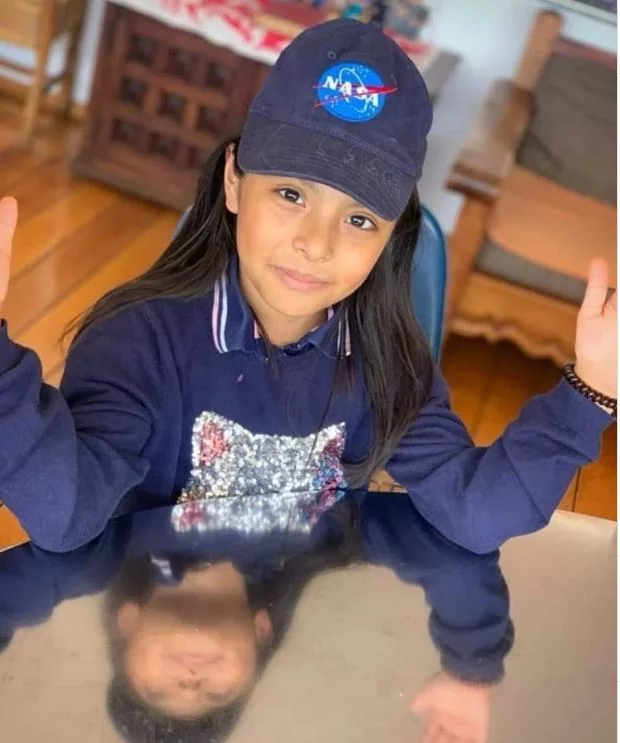 Η μικρή Adhara φορώντας καπελάκι με το λογότυπο της NASA