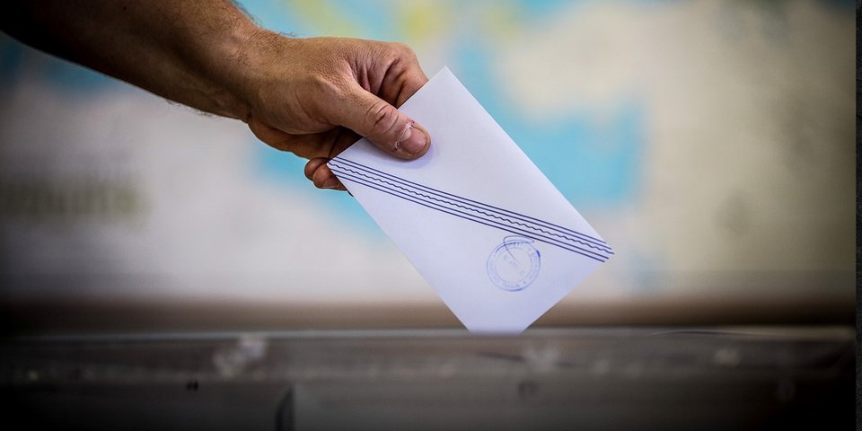 Εκλογές 2023 / ένας χέρι ρίχνει εκλογικό φάκελο μέσα σε κάλπη