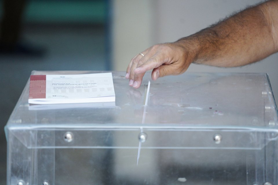 Εκλογές 2023 / ένα χέρι ρίχνει έναν εκλογικό φάκελο μέσα σε κάλπη