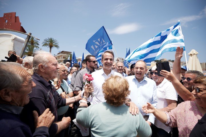 Γυναίκα προσφέρει λουλούδια στον Κυριάκο Μητσοτάκη