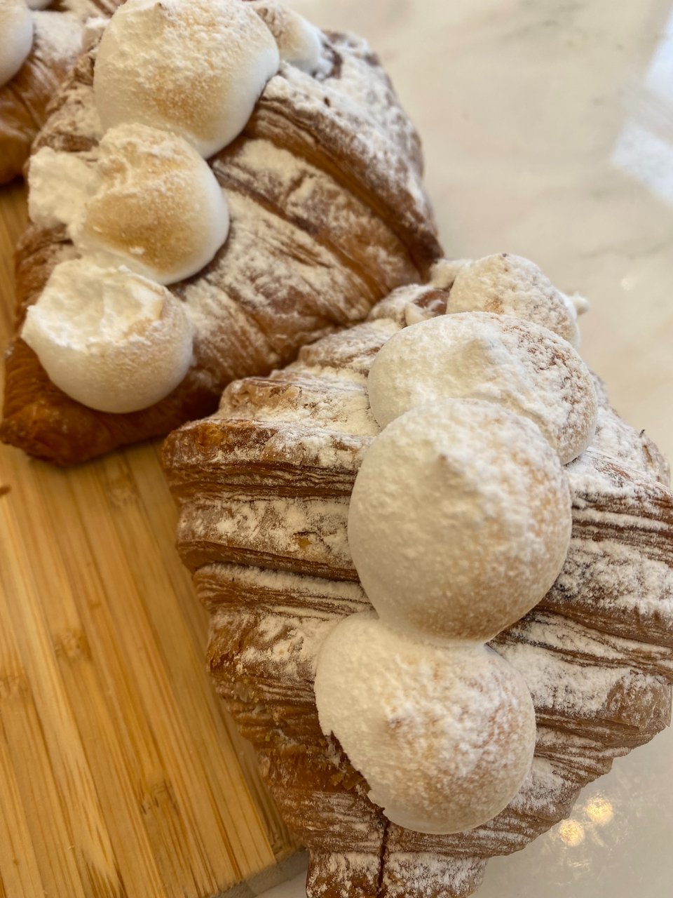 Το κρουασάν με λεμόνι είναι γαρνιρισμένο με μαρέγκα.