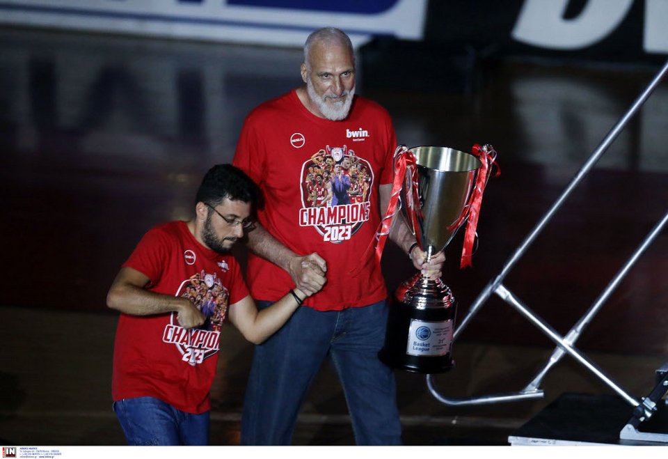    O παλαίμαχος του Ολυμπιακού Αργύρης Καμπούρης κρατώντας από το χέρι τον νεαρό Γιάννη Αλαμπασίνη και την κούπα του πρωταθλήματος-Φωτογραφία INTIME NEWS 