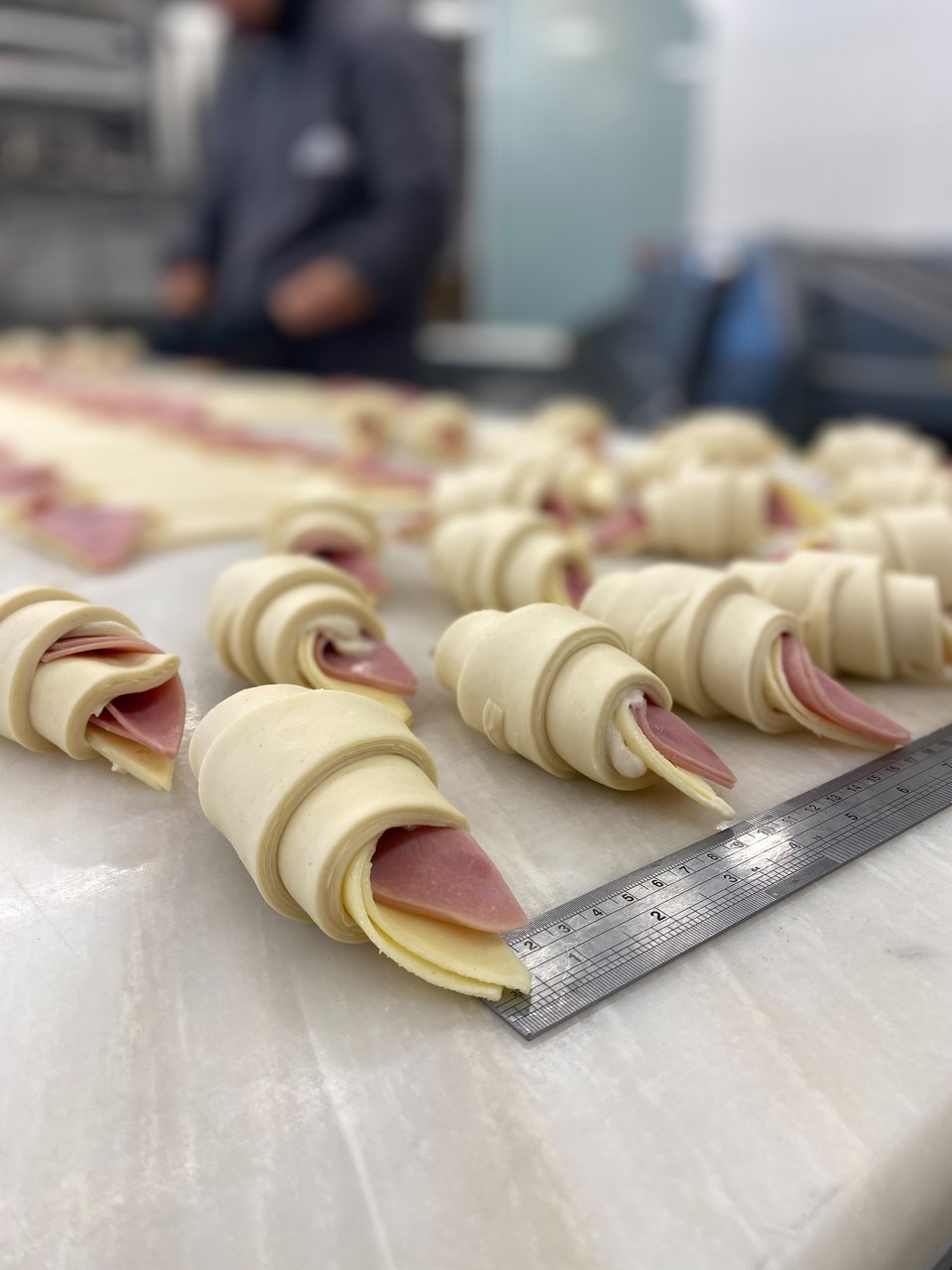 Η ζύμη για κάθε κρουασάν μετριέται με το χάρακα πριν κοπεί.  