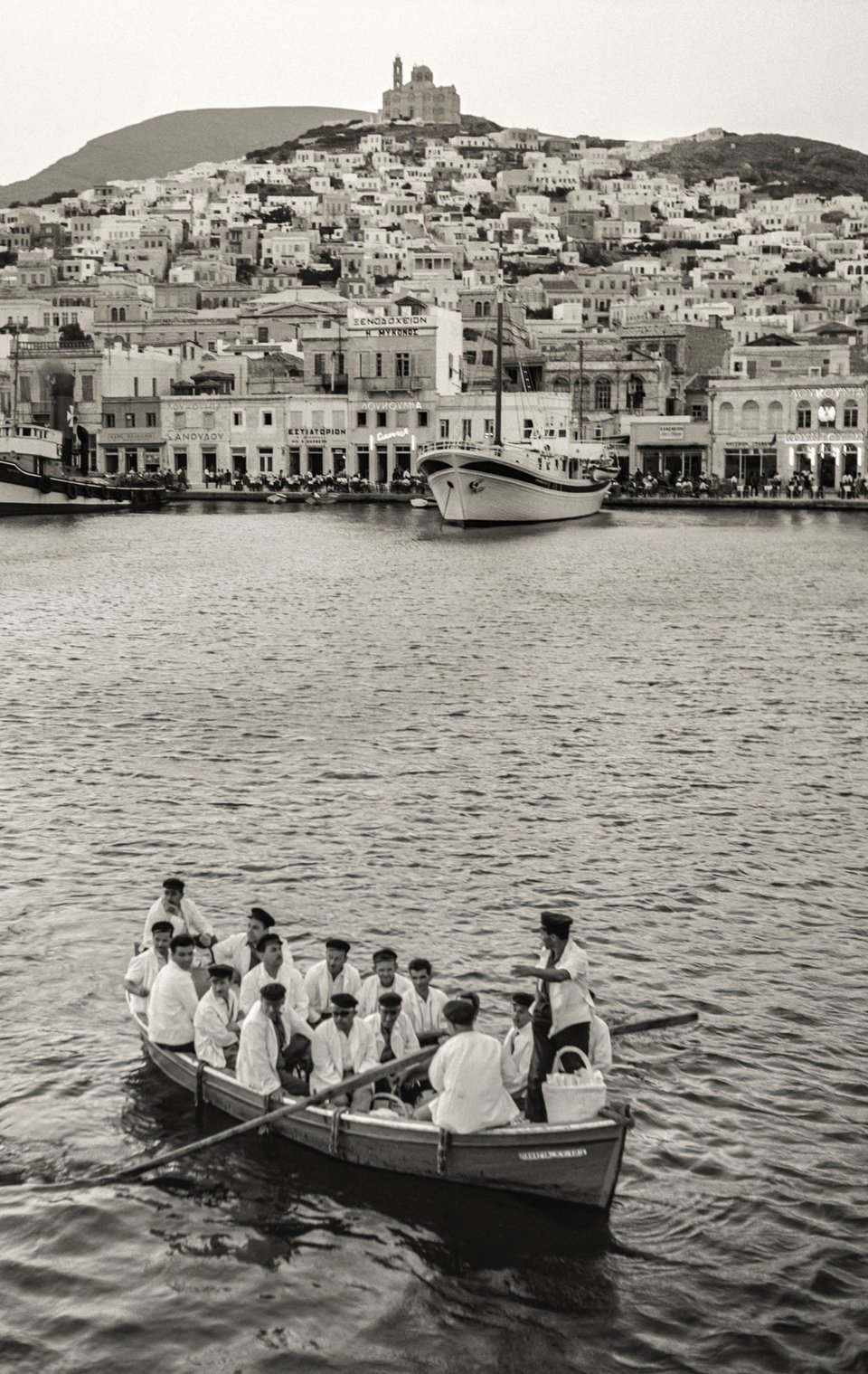 Σύρος, 1950. Η Σύρος ήταν σημαντικός ναυτιλιακός κόμβος και εμπορικό κέντρο στο Αιγαίο ακόμη και πριν από την Ελληνική Επανάσταση. Παρέμεινε δε έτσι εκείνη την περίοδο παρόλο που το λιμάνι του Πειραιά είχε την πρωτοκαθεδρία