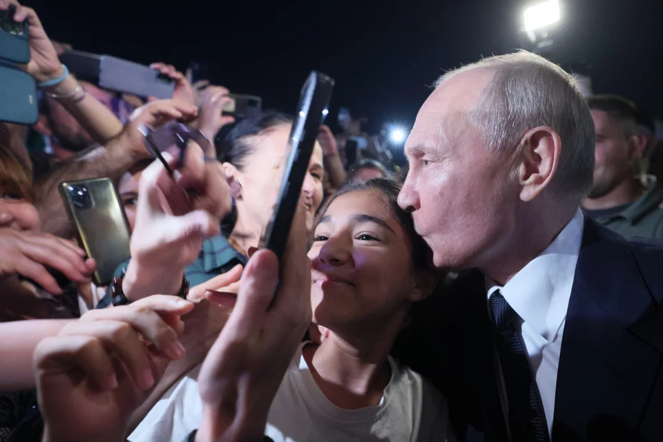 Στις φωτογραφίες που έδωσε στη δημοσιότητα το Κρεμλίνο από την επίσκεψη του Πούτιν στο Ντερμπέντ,  απεικονίζεται ο Ρώσος πρόεδρος να ποζάρει για selfies με οπαδούς του και να φιλά στο κεφάλι ένα κορίτσι