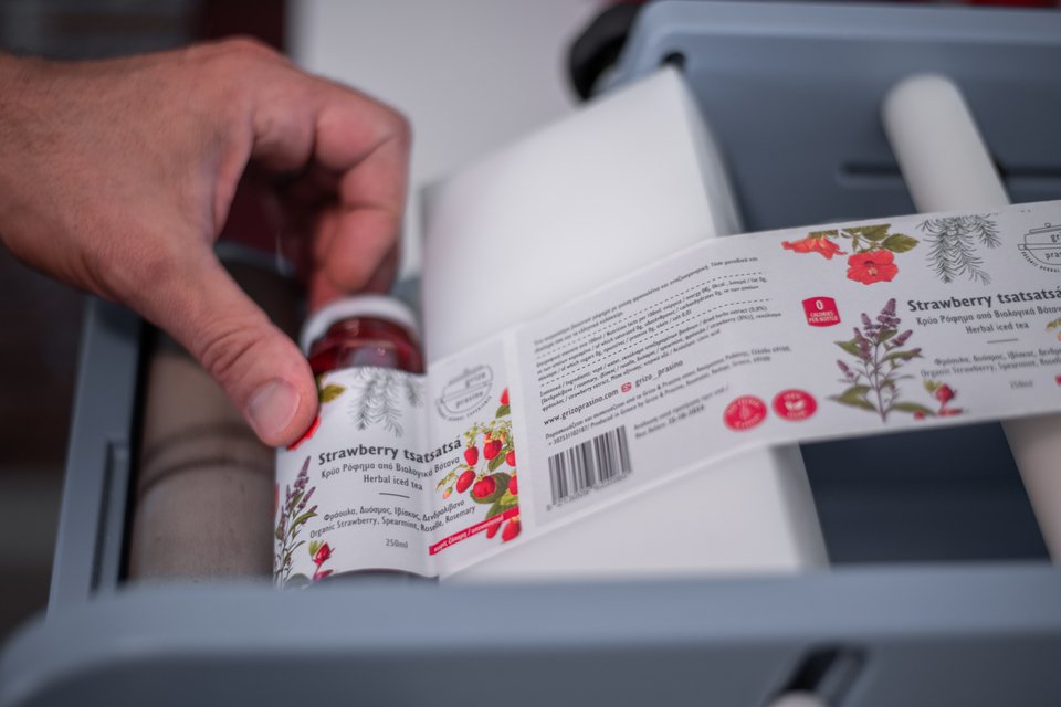 Η στιγμή που η ετικέτα μπαίνει στο μπουκαλάκι / Φωτογραφία: Yana Chilingarova 