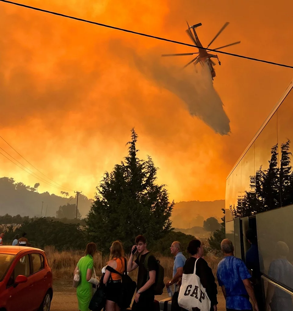 Ελικόπτερο ανοίγει δρόμο με ρίψη νερού ανάμεσα στις φλόγες στην παραλία της Ιξιάς της Ρόδου