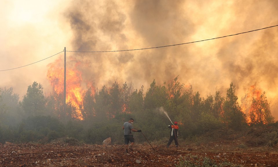 Εθελοντές σβήνουν φωτιά στη Μάνδρα