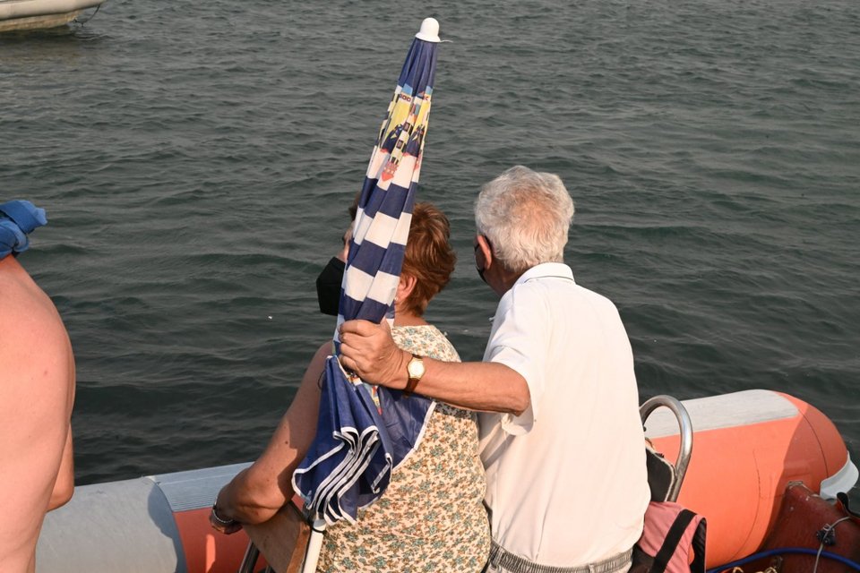 Ενα ηλικιωμένο ζευγάρι αγκαλιά στο φουσκωτό έτοιμοι να μεταφερθούν στο Βόλο