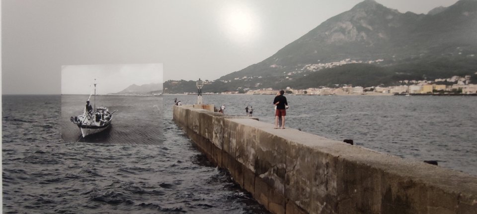 Χαρακτηριστική φωτογραφία της έκθεσης. Ο Γιώργος Σαλαμέ έχει φωτογραφήσει τον μώλο σήμερα. Μέσα ενθέτει με έναν τρόπο αδιόρατο την εικόνα από ένα καΐκι, όπως βγήκε από ένα φωτογραφικό άλμπουμ. / iefimerida