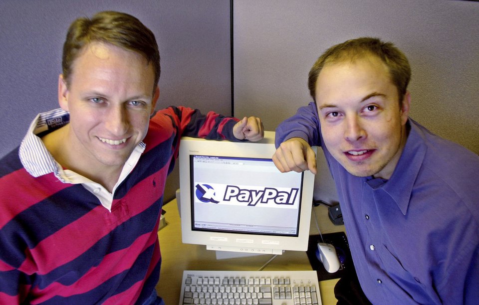 Ο διευθύνων σύμβουλος της PayPal Peter Thiel, αριστερά, και ο ιδρυτής Elon Musk, δεξιά, ποζάρουν με το λογότυπο της PayPal το 2000