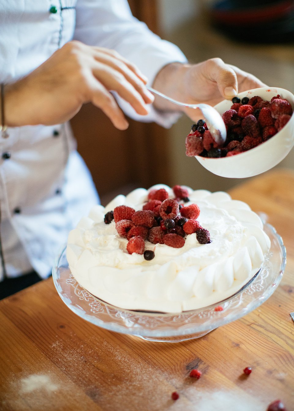 Η λευκή μαρέγκα της πάβοβα αποκτά χρώμα χάρη στα φρούτα του δάσους. Μετά προστίθεται η φράουλα. 