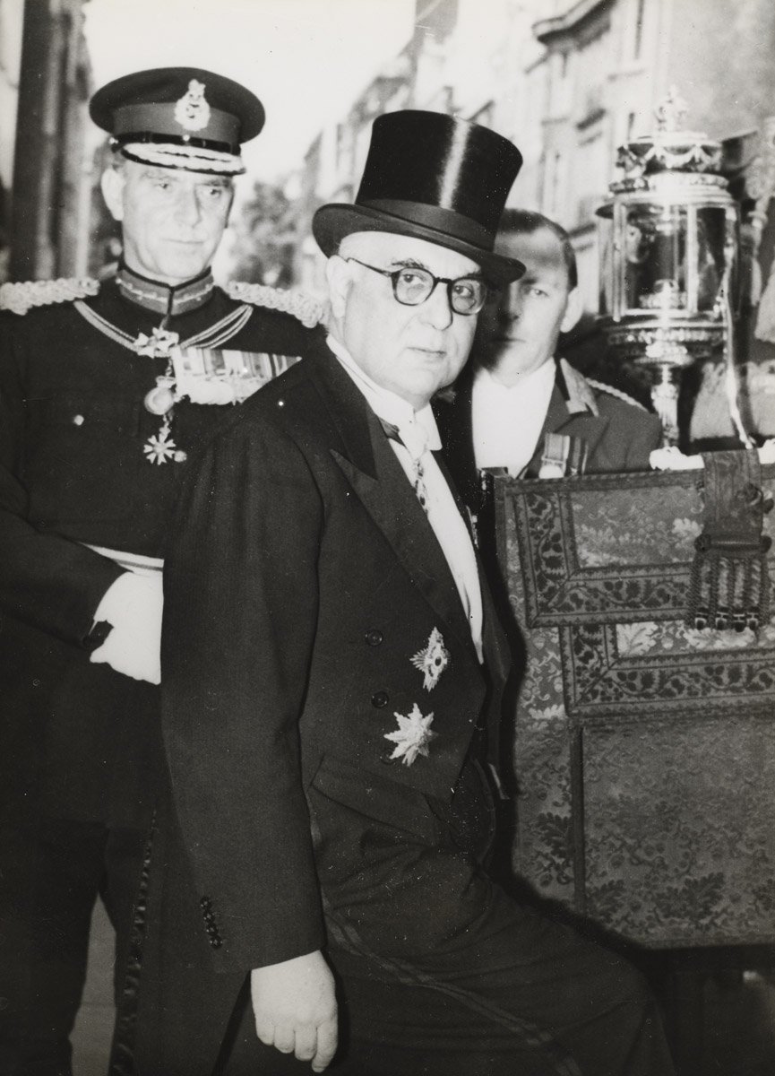 Λονδίνο, 6 Ιουνίου 1957. Ο Γιώργος Σεφέρης μεταβαίνει από την πρεσβευτική κατοικία στο παλάτι του Μπάκιγχαμ με την παραδοσιακή άμαξα, όπου θα επιδώσει τα διαπιστευτήριά του στη βασίλισσα Ελισάβετ. Η φωτογραφία αυτή διανεμήθηκε από το Γαλλικό Πρακτορείο Ειδήσεων την ημέρα της αναγγελίας του Νόμπελ Λογοτεχνίας στον Σεφέρη.