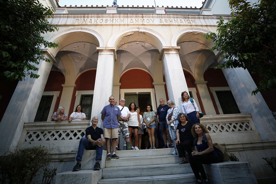 Η πρόεδρος του "The Eftychia Project" Λίντα Κάρολ Τρότερ ( ή Ευτυχία Νούλα) (Κ), μαζί με άνδρες και γυναίκες που γεννήθηκαν στην Ελλάδα αλλά υιοθετήθηκαν δεκαετίες πριν στην Αμερική, φωτογραφίζονται μπροστά στο σημερινό κτήριο της Πινακοθήκης του δήμου Αθηναίων, όπου παλιά λειτουργούσε το Βρεφοκομείο Αθηνών