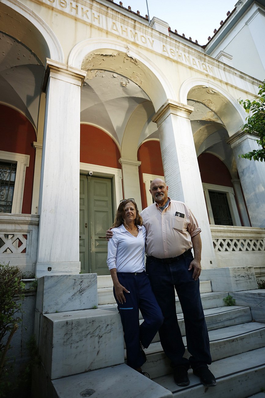 Ο Steven Graeter και η Lisbeth Graeter, που γεννήθηκαν στην Ελλάδα αλλά υιοθετήθηκαν δεκαετίες πριν στην Αμερική, φωτογραφίζονται μπροστά στο σημερινό κτήριο της Πινακοθήκης του δήμου Αθηναίων, όπου παλιά λειτουργούσε το Βρεφοκομείο Αθηνών