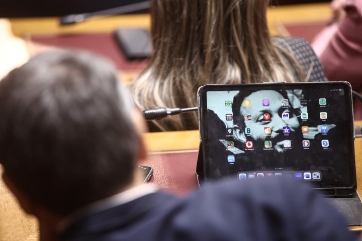 Ο Αλέξης Τσίπρας και μπροστά το τάμπλετ του Ευκλείδη Τσακαλώτου με φόντο φωτογραφία του Άρη Βελουχιώτη- Φωτογραφία: Dimitris Kapantais / SOOC