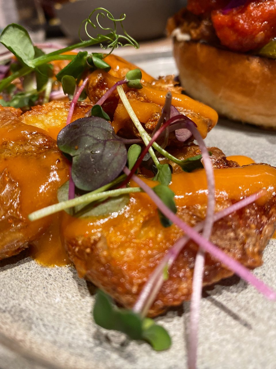 To burger συνοδεύεται από τραγανές patatas bravas.