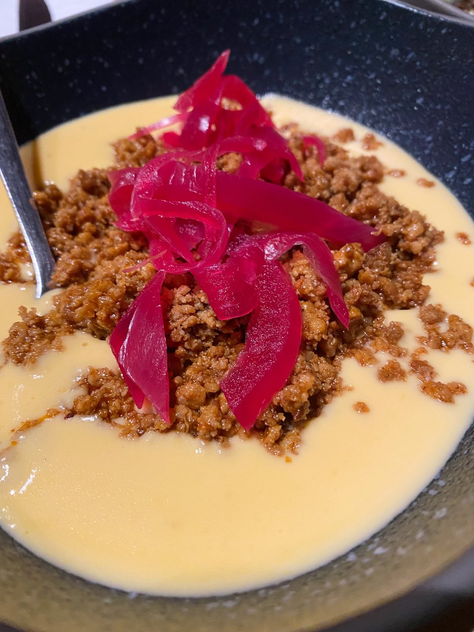 To ορεκτικό Choriqueso με χειροποίητες μοβ πίκλες κρεμμυδιού. 