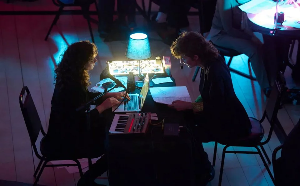 Η Nάντα Ελ Νάζλι και η Σίστερ Σταλόνε καθισμένες στην κονσόλα. Δυο φορές σηκώνεται η κάθε μία και κινείται στο κοινό, μιλώντας ή τραγουδώντας