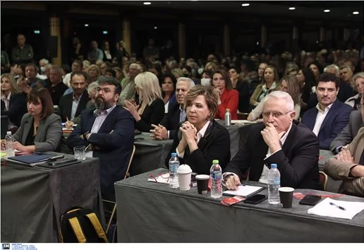 Σκεπτική στην πρώτη σειρά η Όλγα Γεροβασίλη, δίπλα της ο Γιάννης Ραγκούσης