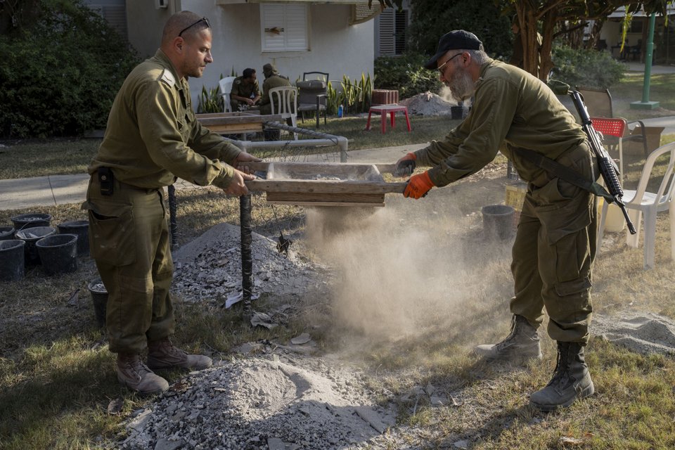 Στρατιώτες των IDF προσπαθούν να βρουν αντικείμενα που θα βοηθήσουν στην αναγνώριση των ανθρώπων που σκοτώθηκαν στο Κιμπούτς Νιρ Οζ, στο Ισραήλ / Φωτογραφία: AP