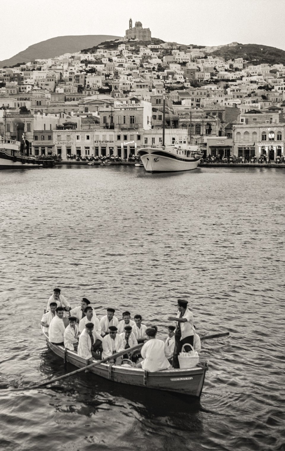 Σύρος, 1950. Η Σύρος ήταν σημαντικός ναυτιλιακός κόμβος και εμπορικό κέντρο στο Αιγαίο ακόμη και πριν από την Ελληνική Επανάσταση. Παρέμεινε δε έτσι εκείνη την περίοδο παρόλο που το λιμάνι του Πειραιά είχε την πρωτοκαθεδρία.