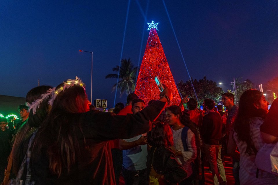 Άνθρωποι βγάζουν φωτογραφίες την παραμονή των Χριστουγέννων στη Βομβάη της Ινδίας / AP Photo/Rafiq Maqbool